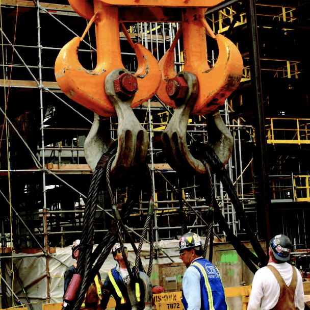 Men working by large crane on construction sign