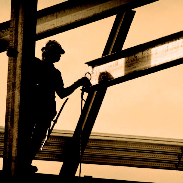 Silhouette of man harnessed to scaffolding