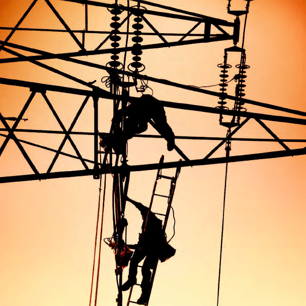 Two men on ladders working on electrical poles