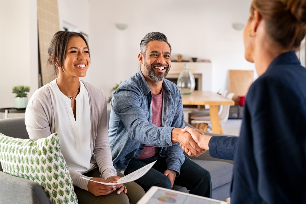 Couple Shaking Hands with Person