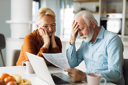 Worried senior couple feeling stressed while have to pay their bills over Internet