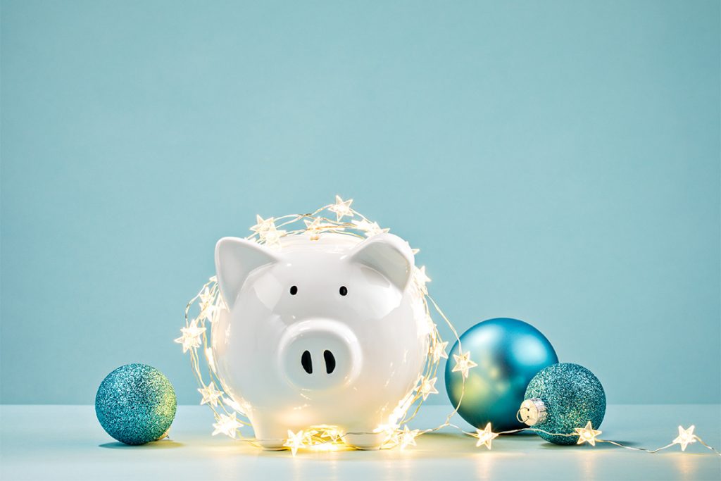 Piggy Bank covered in star lights and surrounded by ornaments