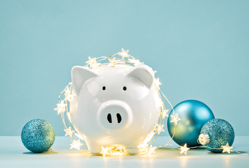 Piggy Bank covered in star lights and surrounded by ornaments