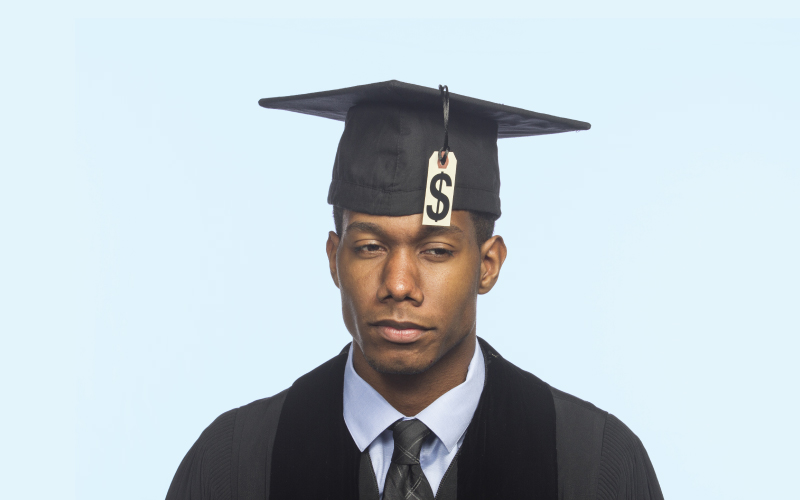 Unhappy student in cap and gown with a price tag on the cap