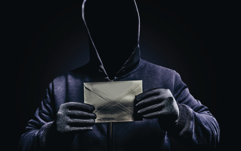 Mysterious sinister figure holding an envelope